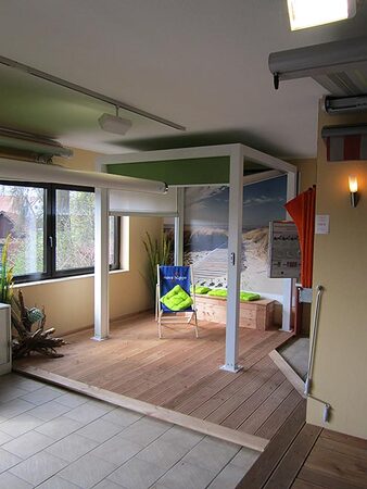 Barrierefreier Indoor-Sonnenschutz mit Markise, Holzterrasse und Strandmotiven.